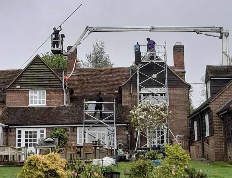 The Moss Cleaners using cherry picker and scaffolding to clean roof safely and professionally in Alton, Hampshire